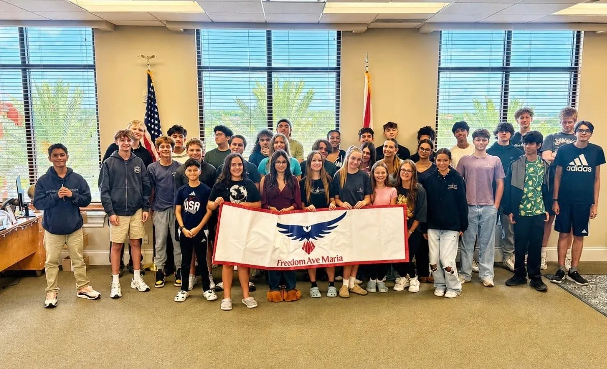 Freedom Ave Maria students holding the eagle banner