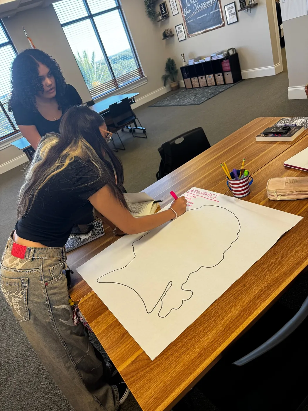 A student drawing a map in an Ave Maria classroom