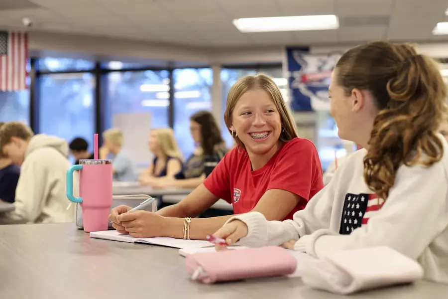 Two Freedom students laughing together in class
